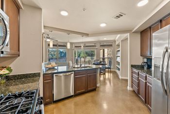 A modern kitchen with a large island and stainless steel appliances. at Bridge at Heritage Woods, Austin, TX